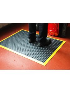 Anti-fatigue mat with textured surface and yellow safety border – slip-resistant industrial floor mat.