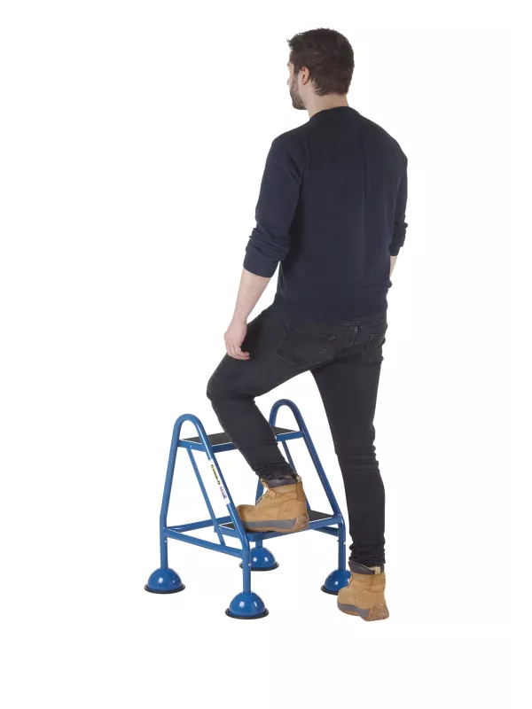 Man stepping onto blue safety step stool with handrails
