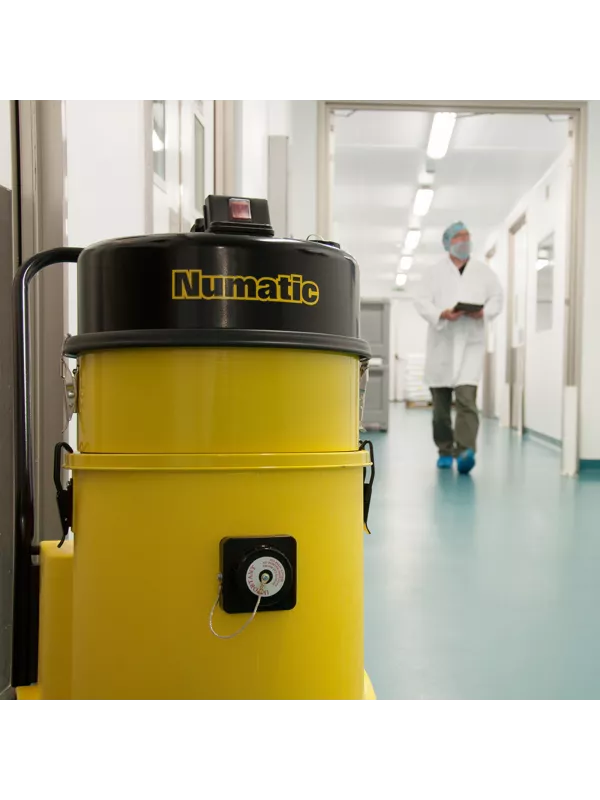 Yellow Numatic vacuum cleaner in a cleanroom or laboratory corridor.