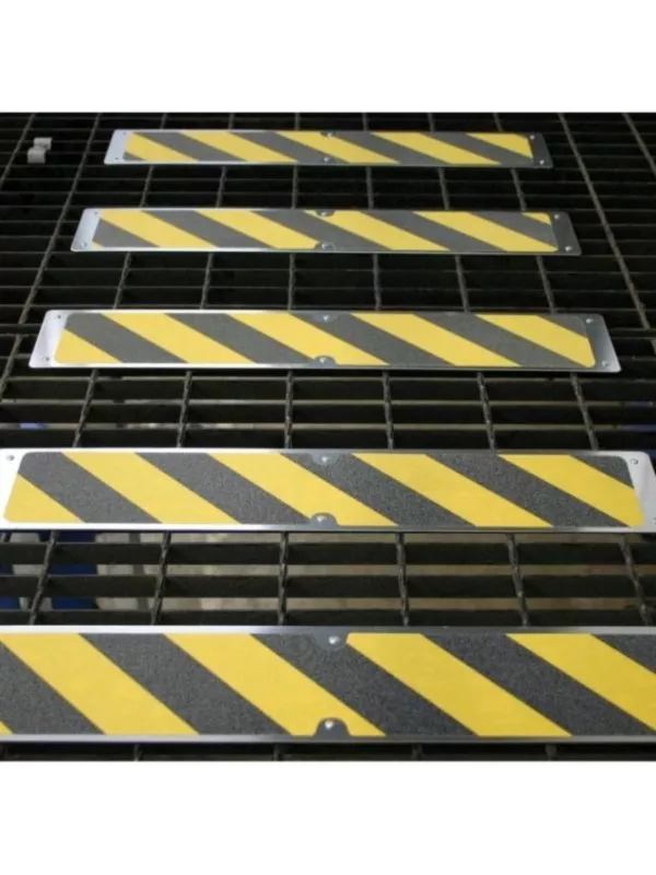 High-visibility anti-slip stair nosing strips installed on steel grating stairs