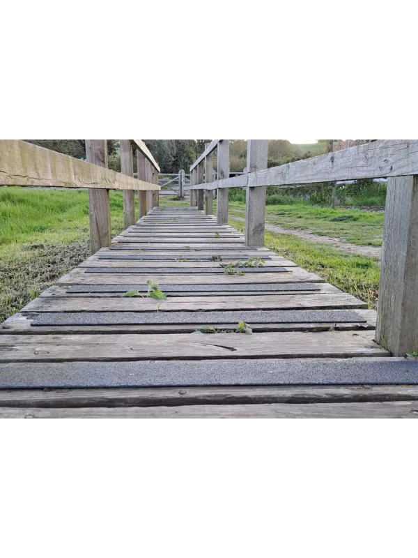 Bridge walkway with GRP anti-slip decking strips installed – durable non-slip safety solution for timber decking.
