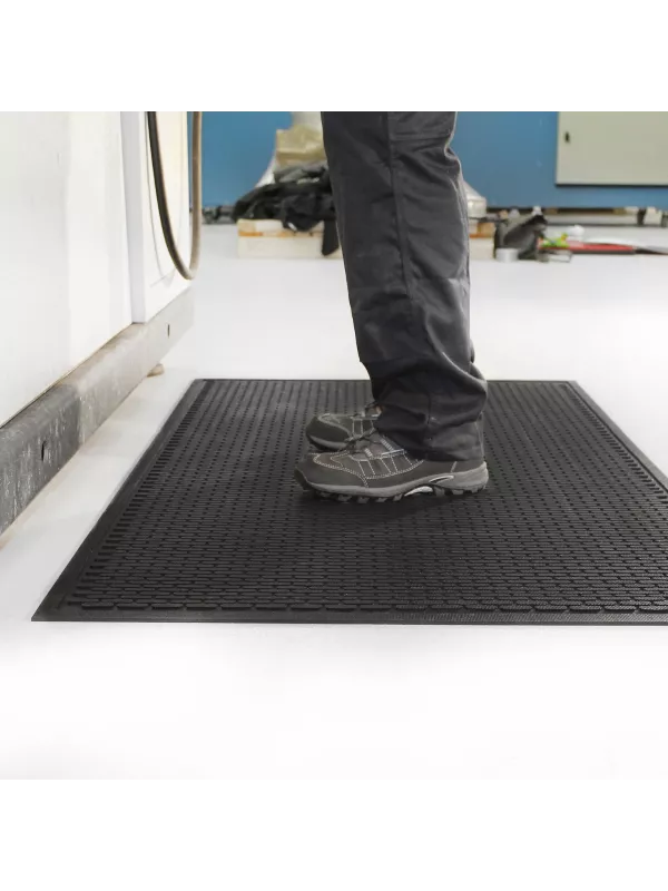 Industrial anti-fatigue mat in use, providing cushioned standing support for factory workers.