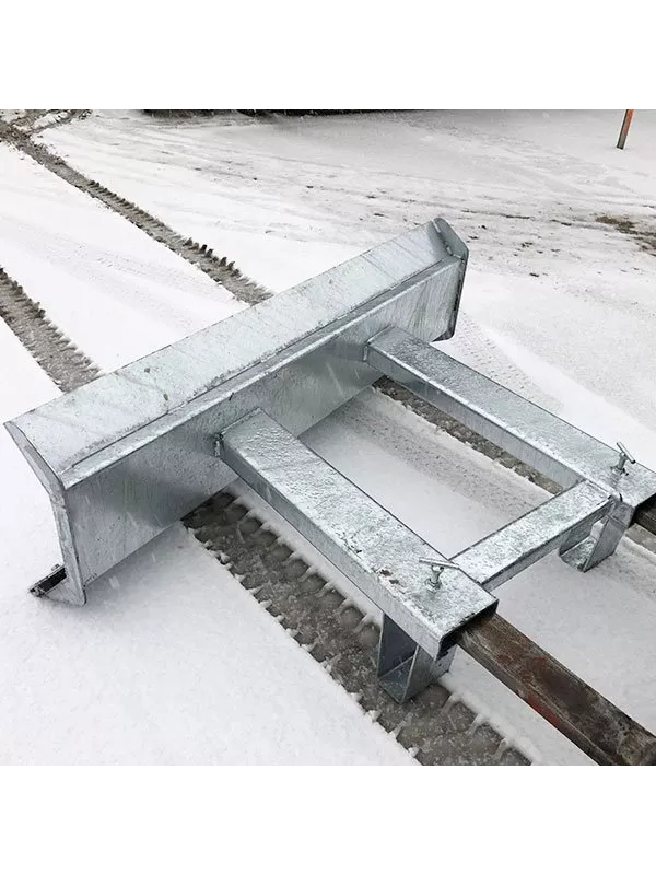 Galvanised forklift snow plough frame positioned on snow-covered ground.