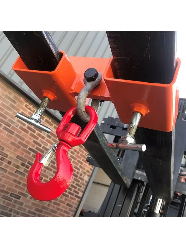 Close-up of forklift fork-mounted hook attachment with red lifting hook.