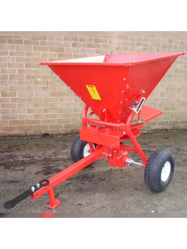 Red towable fertiliser spreader with large hopper and pneumatic wheels for efficient agricultural and grounds maintenance use.