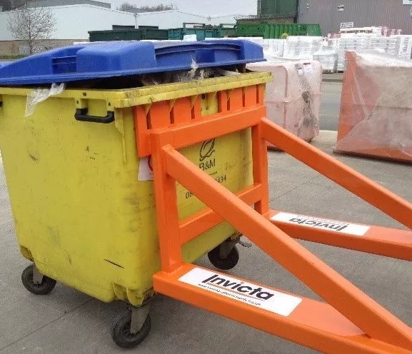 Forklift wheelie bin lifter attachment in use with yellow waste bin – heavy-duty forklift bin handler for efficient waste management.