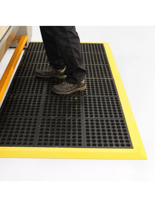 Anti-fatigue safety mat in use at industrial workstation