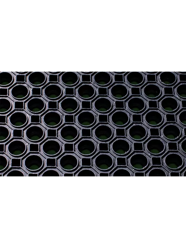 Close-up of black rubber ring mat with circular drainage holes – durable anti-slip industrial floor mat.