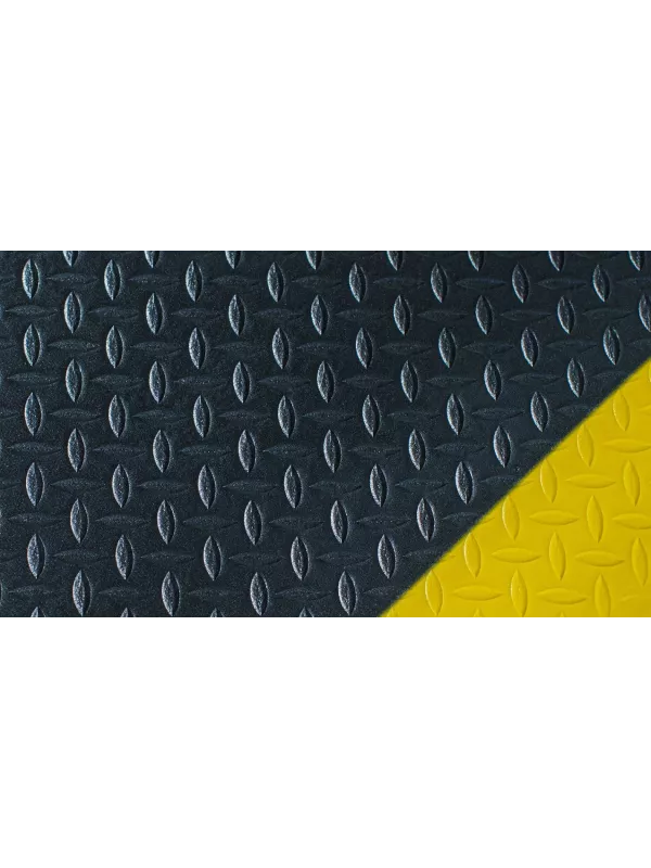 Close-up of anti-fatigue mat with diamond plate pattern and yellow border – slip-resistant industrial mat.