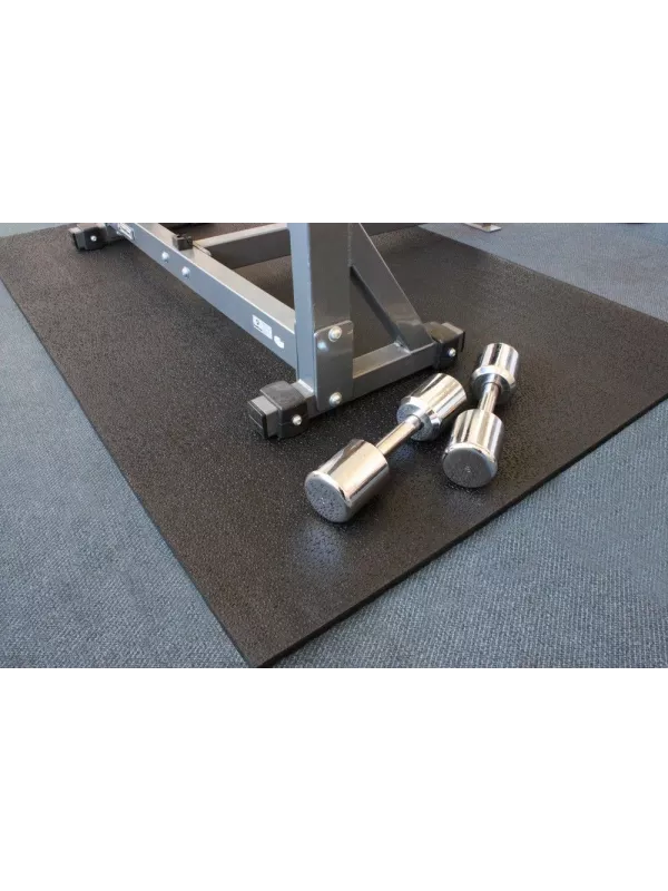 Heavy-duty rubber gym mat under weight bench with dumbbells – protective flooring for gyms, fitness centres, and workout areas.