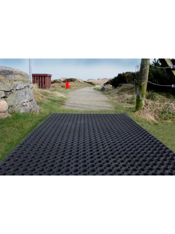 Outdoor pathway covered with heavy-duty rubber ring mat – slip-resistant ground protection matting