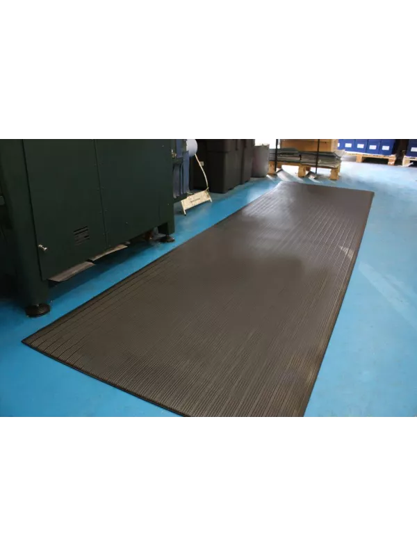 Large anti-fatigue mat placed in industrial workspace – cushioned safety mat for worker comfort.