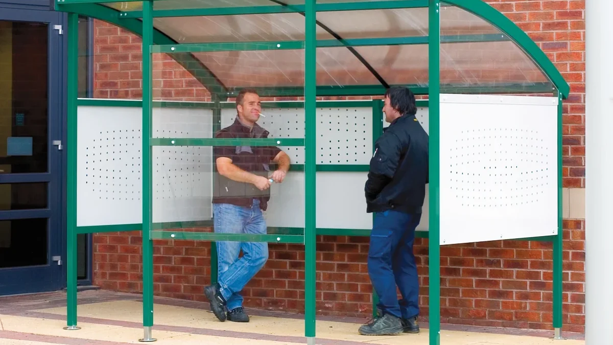 Outdoor workplace smoking shelter with employees outside a commercial building