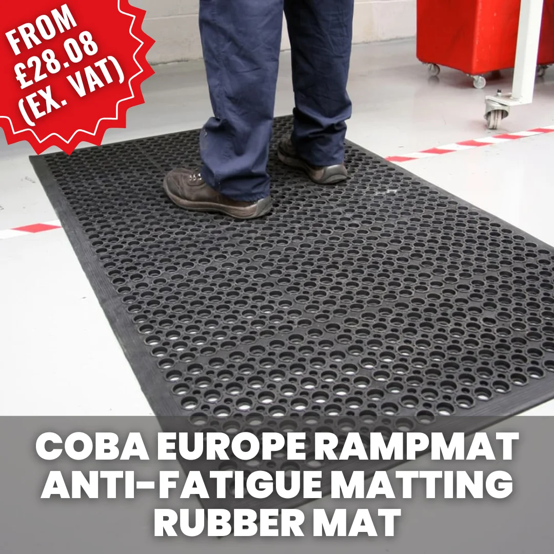 Worker standing on a COBA Rampmat anti-fatigue rubber mat with drainage holes, used in industrial or workshop environments to reduce standing fatigue.