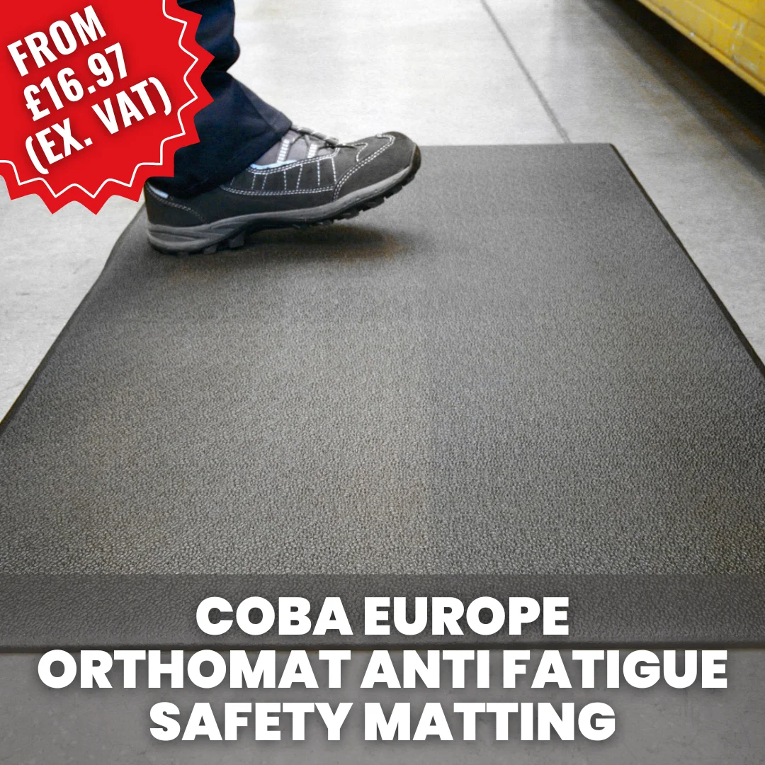 Worker standing on a COBA Orthomat anti-fatigue safety mat in a warehouse or industrial environment, providing cushioning and comfort for standing tasks.